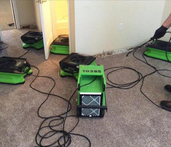 water damaged carpets being dried by SERVPRO drying equipmennt
