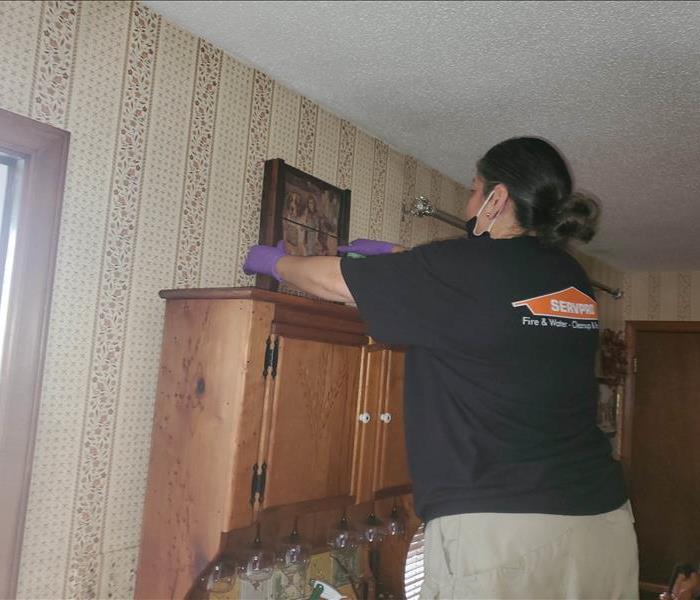 SERVPRO employee putting picture back