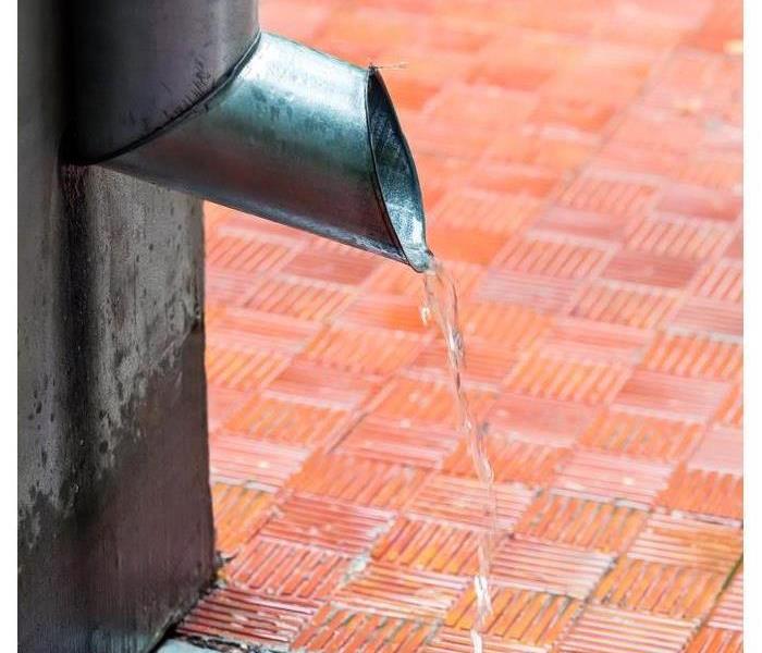 Water flowing from a metal drain pipe